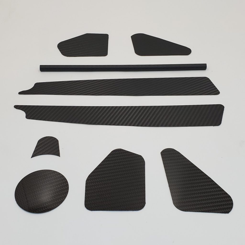 The carbon fiber trim kit is back! Our real carbon fiber trim kit adds some high tech race technology to your 2015+ Indian Scout. The carbon fiber "inserts" are adhesive backed with 3M adhesive to ensure that they'll stay put for years to come. This 9 piece set includes two frame inserts, two neck inserts, two belt cover inserts, two radiator cover inserts and a shift rod cover that slides over the factory shift rod. Fits 2015+ Indian Scout Models. Made in USA NOTE: Because the rod ends can be turned to adjust the height of the toe shift lever, we leave the cover a little long at 13" and will need to be cut to length with a hacksaw. The "Inserts" are high gloss carbon fiber while the shift rod cover is matte carbon fiber. Finish: Shift Rod Cover - Matte Carbon Fiber Carbon Fiber Sheets - High Gloss Carbon Fiber Fitment: For use with 2015+ Indian Scout Models.