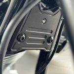 This beautifully designed cover provides a remedy to cover a not so attractive area. It also matches the design of the cover, which elegantly closes the open frame triangle. This cover is also bead-blasted and black anodized. Details: CNC-milled, surface bead-blasted and anodized in satin black. Covers the distributor of the front brake lines. Included in delivery: Cover Mounting material Small parts Note: Only fits if no crash bars are fitted to the motorcycle.